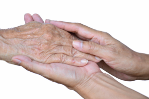 End-of-life care patient holding hands with caregiver at Tore's Home in Brevard, NC